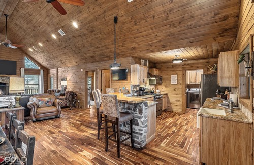 Shreveport House | Relax at this lakefront log cabin on private Emerald Isle, designed for easy outdoor living. Enjoy the hot tub, paddle out with kayaks and canoes, gather around the fire pit, or grill and unwind by the water.