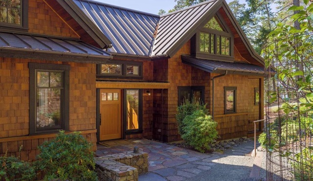 Magnificent waterfront home where sustainability meets luxury. Five private wooded acres, 400ft of rocky bluff shoreline, Chef's Kitchen, Stone Fireplaces, Heated Tile Floors & Unforgettable Sunsets over Wasp Passage. Your perfect PNW escape awaits. in Eastsound