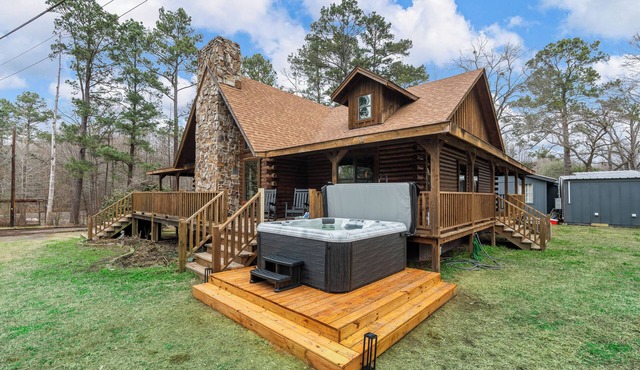 Relax at this lakefront log cabin on private Emerald Isle, designed for easy outdoor living. Enjoy the hot tub, paddle out with kayaks and canoes, gather around the fire pit, or grill and unwind by the water.